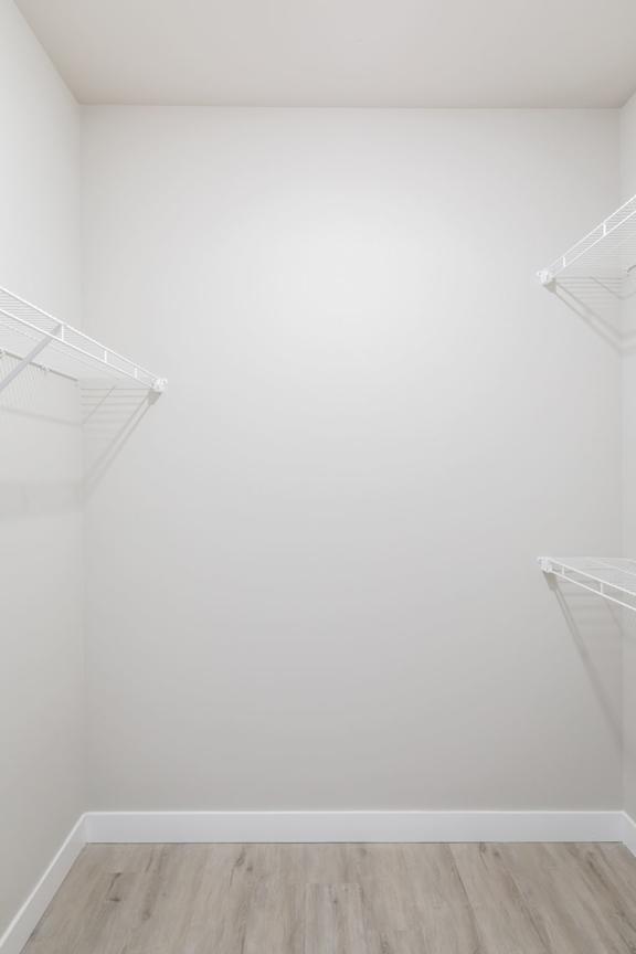 A white closet with two shelves.