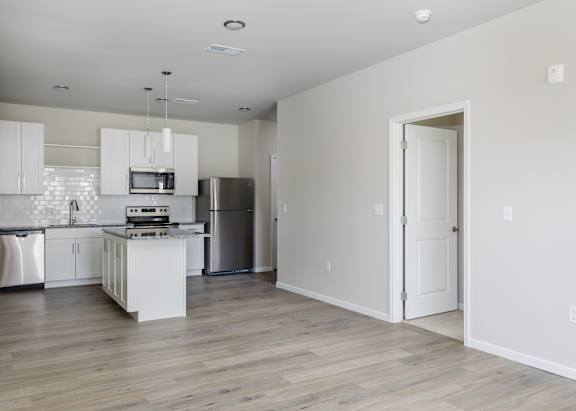 A modern kitchen with white cabinets and appliances.
