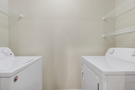 A white washing machine and dryer in a laundry room.