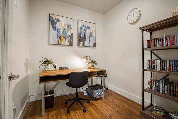 A room with a desk, chair, and bookshelf.