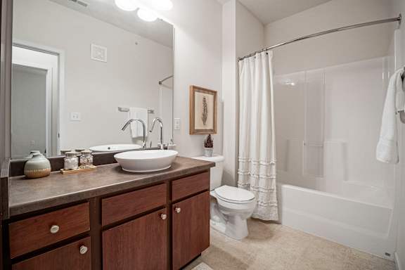 A bathroom with a white toilet and a white bathtub.