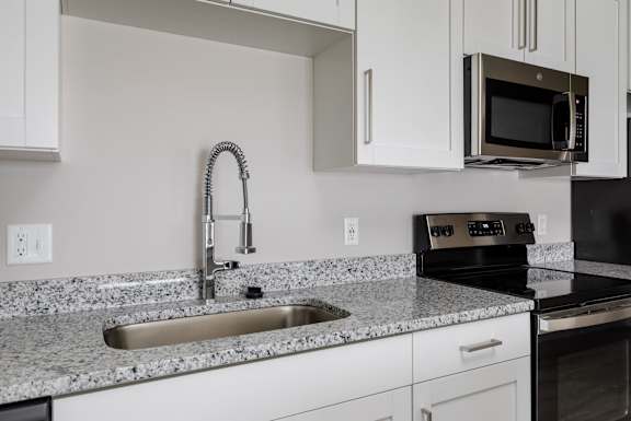 A kitchen with a sink and a microwave.
