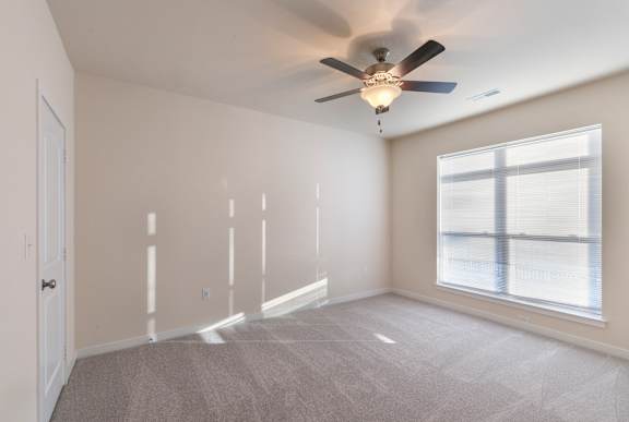 A room with a ceiling fan and a window.