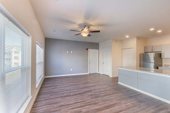 A room with a ceiling fan and wooden flooring.