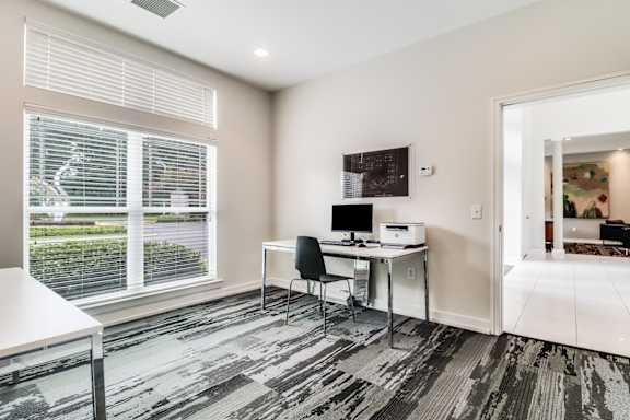 A room with a desk and a chair in front of a window.
