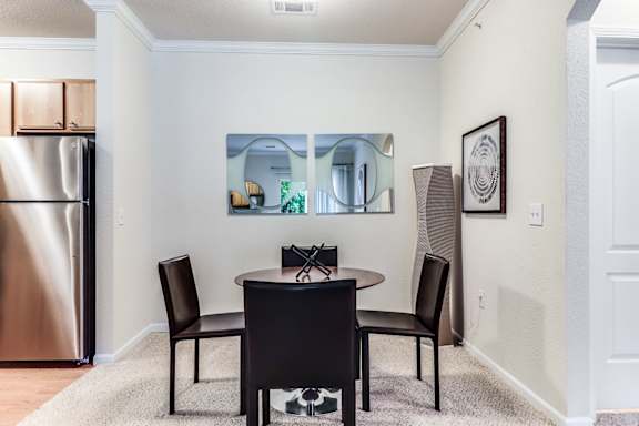 A dining room with a table and chairs.