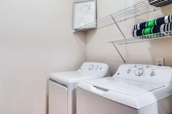 A white washing machine and dryer in a laundry room.