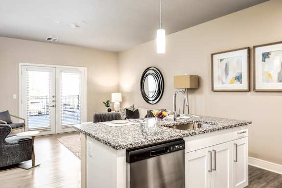 A modern kitchen with a granite countertop and a black dishwasher.