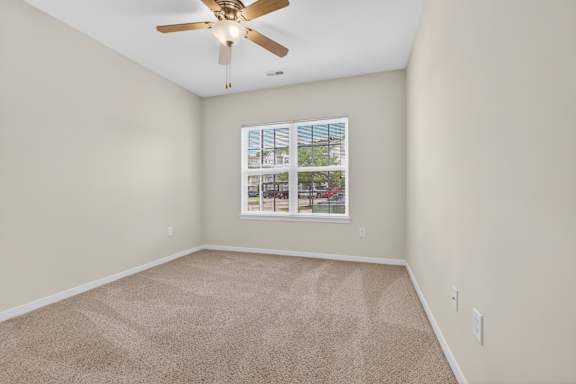 A room with a ceiling fan and a carpeted floor.
