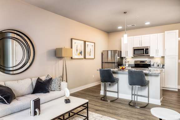 A modern kitchen with a bar stool and a fridge.