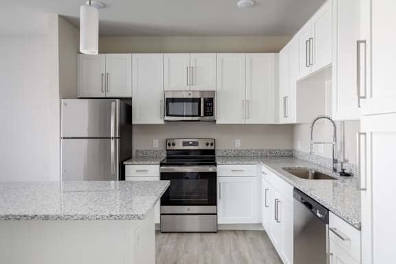 A kitchen with white cabinets and appliances.