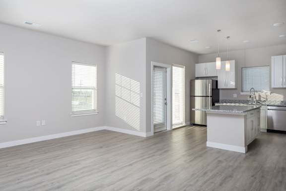 A modern kitchen with a white island and stainless steel appliances.