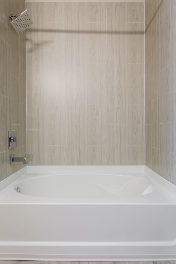 a large white bathtub in a bathroom  at The Edison at Tiffany Springs, Missouri, 64153