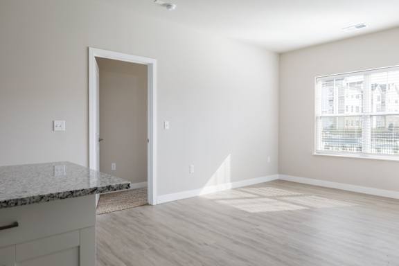 A room with a granite countertop and wooden flooring.