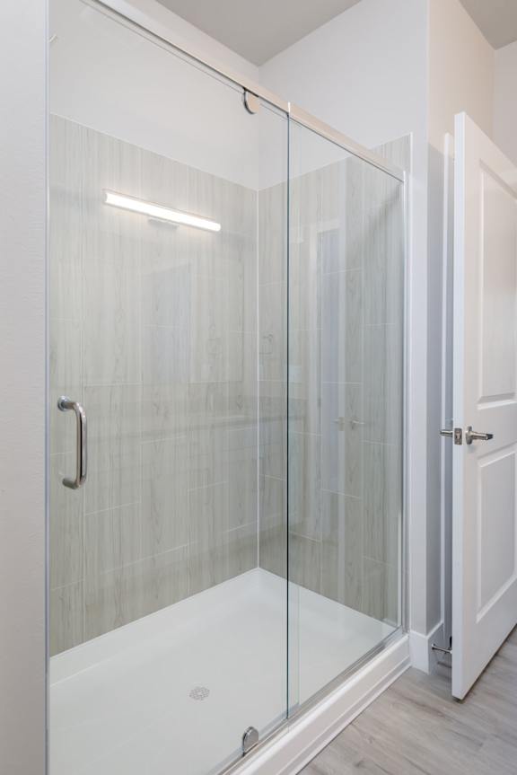 A white door with a glass shower stall in the bathroom.
