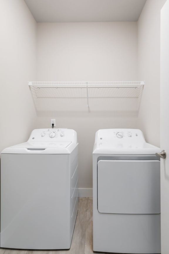 a washer and dryer in a laundry room  at The Edison at Tiffany Springs, Kansas City, 64153