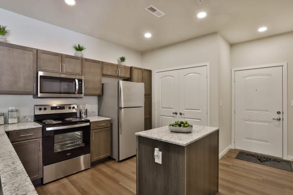 a kitchen with stainless steel appliances and wooden cabinets  at Aventura at Hawk Ridge, Missouri, 63367