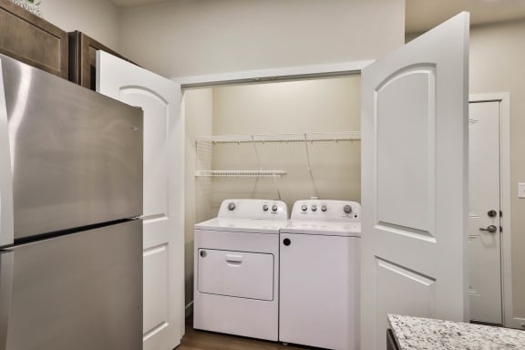 a kitchen with a washer and dryer and a refrigerator at Aventura at Hawk Ridge, Missouri
