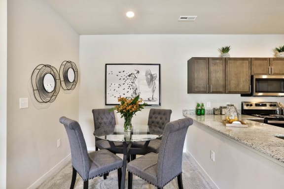 a dining room with a table and chairs and a kitchen  at Aventura at Hawk Ridge, Lake St Louis, Missouri