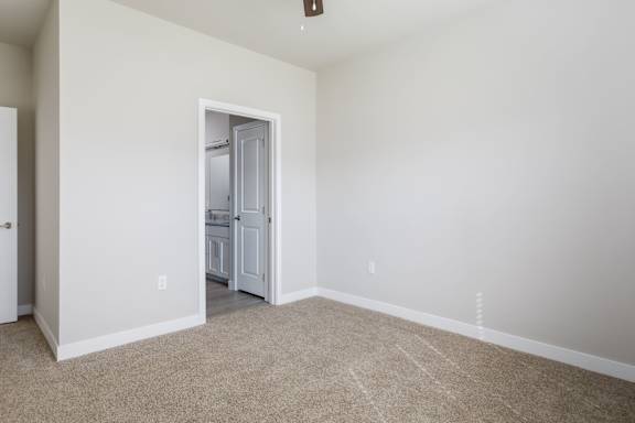 A room with a white door and a carpeted floor.