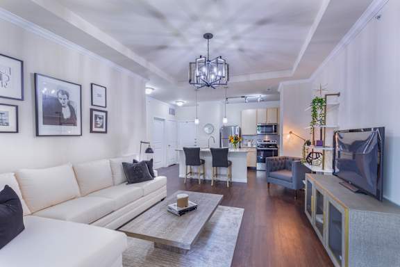A modern living room with a white sofa and a coffee table.