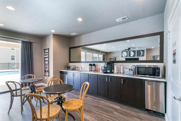 A kitchen with a table and chairs.