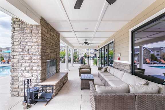 A patio with a couch, table, and a fireplace.
