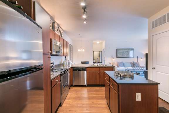 A modern kitchen with stainless steel appliances and wooden cabinets.