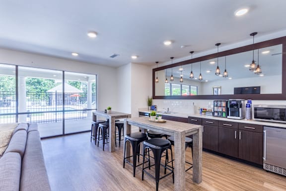 A modern kitchen with a bar area and a view of the backyard.