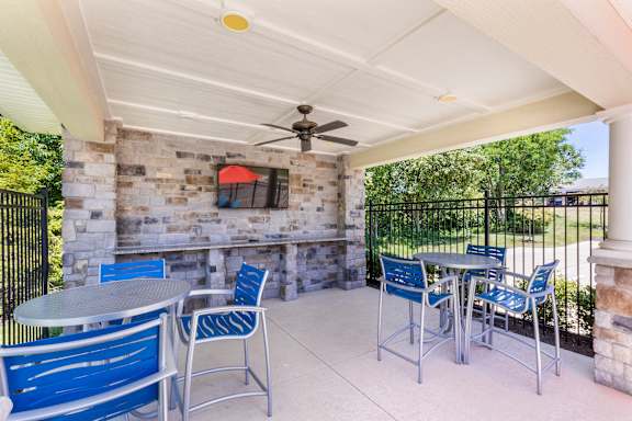 A patio with a table and chairs and a fan.