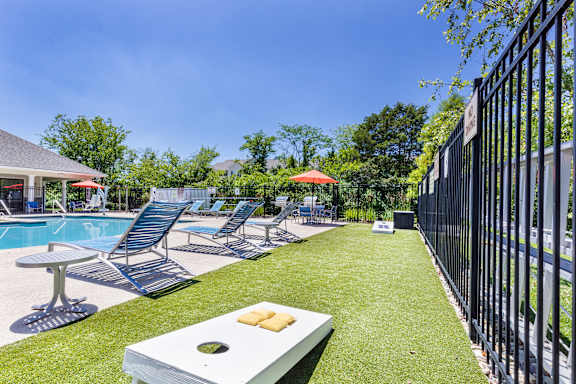 A poolside area with lounge chairs and a table.