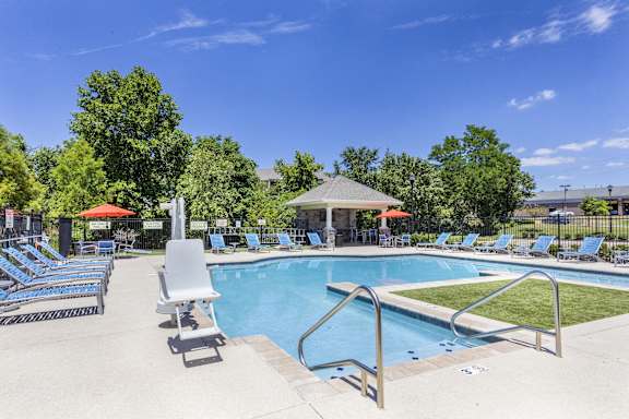 A pool with a gazebo and sun loungers.