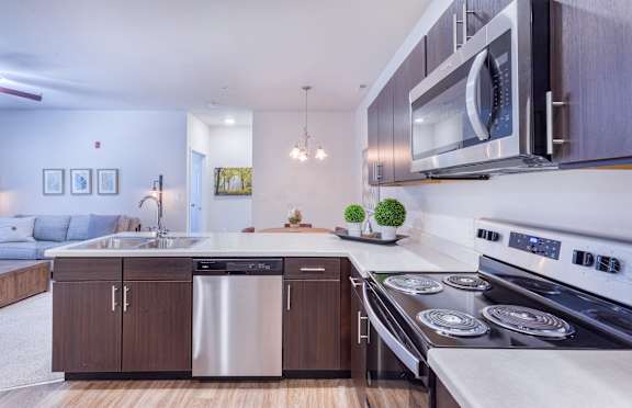 A modern kitchen with stainless steel appliances and wooden cabinets.