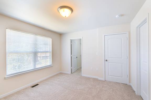 A room with a carpeted floor and white walls.