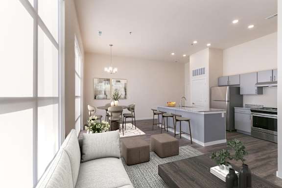 A modern kitchen and living room with a grey sofa and wooden coffee table.