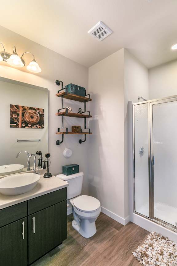 A bathroom with a white toilet, sink, and shower.