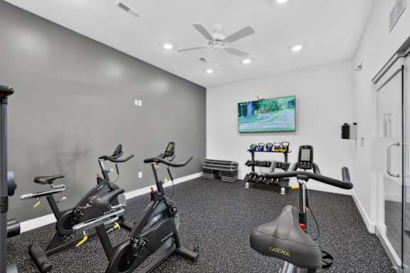 A room with a grey floor and a television on the wall.