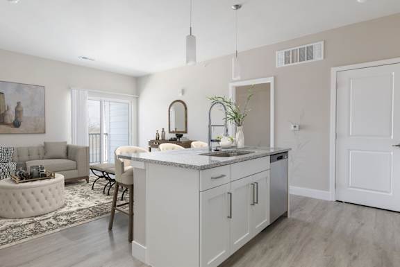 A modern kitchen with a large island and a dining area.