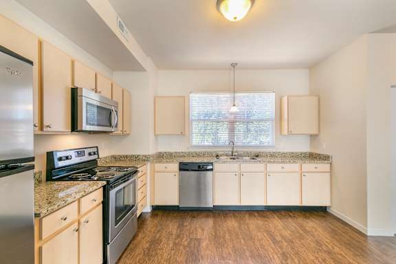 A kitchen with wooden cabinets and stainless steel appliances.