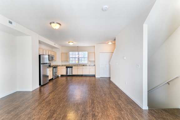 A spacious kitchen with a refrigerator, sink, and stove.