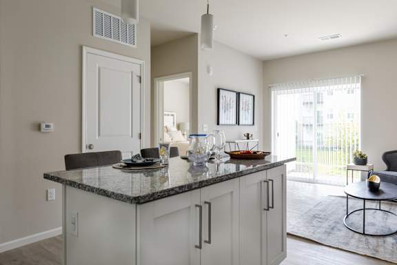 A kitchen with a granite countertop and white cabinets.