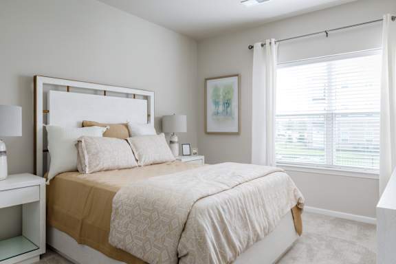 A bedroom with a large bed and a painting on the wall.