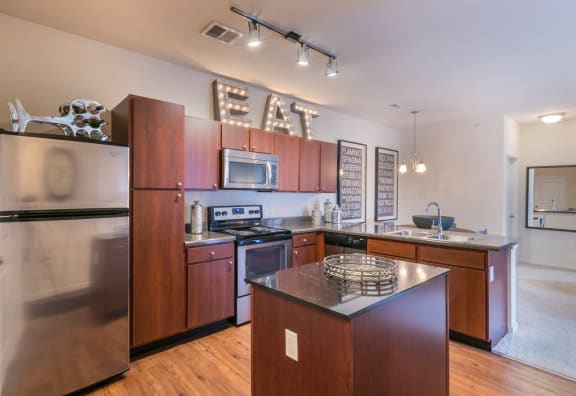 a kitchen with wooden cabinets and stainless steel appliances  at Aventura at Mid Rivers, St. Charles, 63304