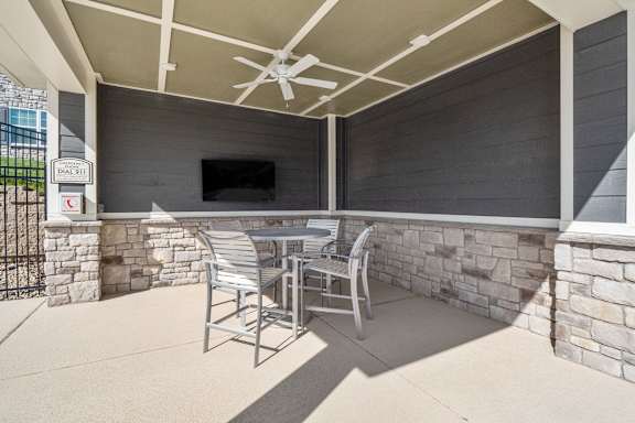 A patio with a table and chairs and a television.