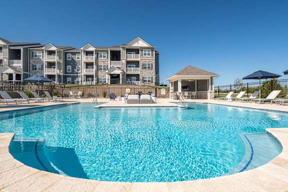 A large swimming pool in front of apartment buildings.