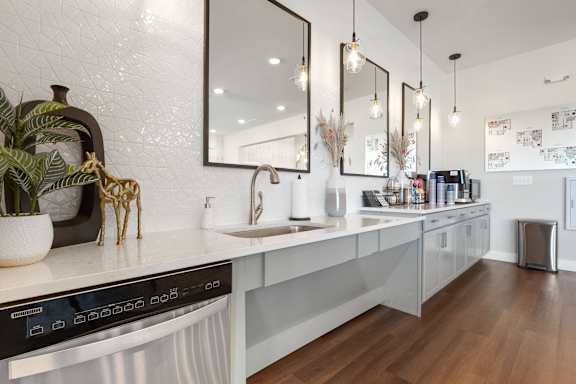 A modern kitchen with a black oven and wooden floors.