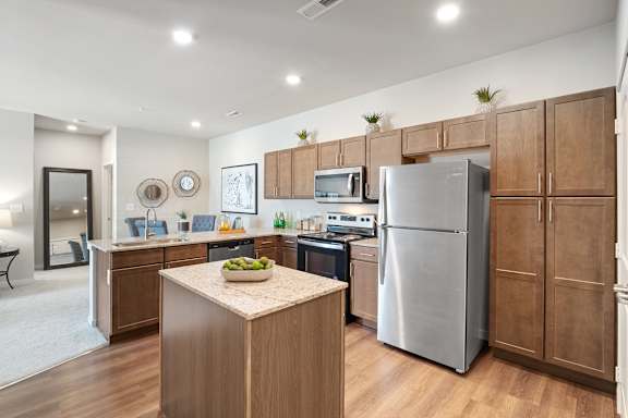 A kitchen with wooden cabinets and a stainless steel refrigerator.