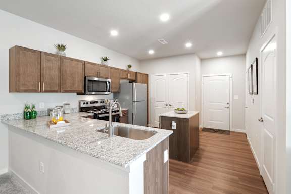A kitchen with a white counter top and wooden cabinets.