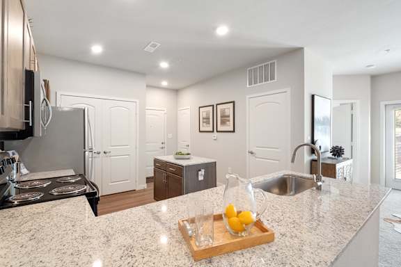 A modern kitchen with granite countertops and stainless steel appliances.