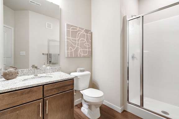 A bathroom with a toilet, sink, and shower.